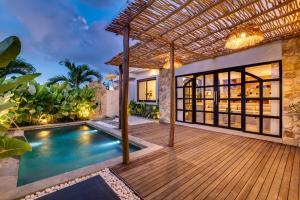 an outdoor deck with a swimming pool and a pergola at Tresna Villa Tumbak Bayuh Utara in Dalung