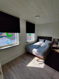 a bedroom with a bed in a room with two windows at JP Apartment Floor 1 in Grindsted