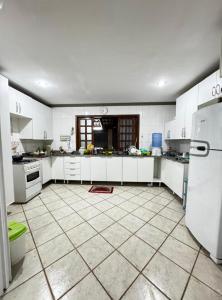 a kitchen with white cabinets and a tiled floor at Casa Marron in Anchieta