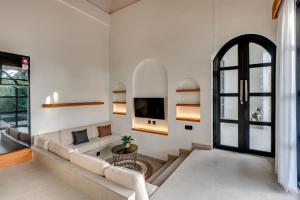 a living room with a couch and a tv at Tresna Villa Tumbak Bayuh Utara in Dalung