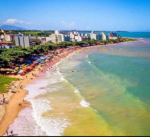 a beach with a bunch of people and the ocean at Casa Marron in Anchieta
