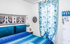 a bedroom with a blue bed and a curtain at Bilo Panorama in Castelsardo