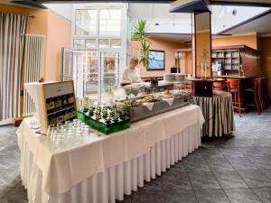 a buffet table in a restaurant with a woman behind it at Zur Alten Schmiede in Naumburg