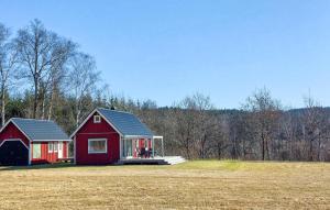 a red house sitting on top of a field at Amazing Home In Slättåkra in Slättåkra