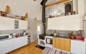 a kitchen with white cabinets and a stove at Amazing Home In Slättåkra in Slättåkra