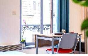 a table and chair in a room with a window at Naroc1 in Lille +11 photos
