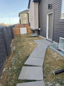 a garden with a walkway next to a house at Hidden Gem in Airdrie