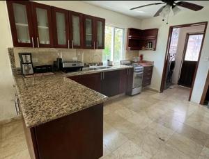 a kitchen with wooden cabinets and a counter top at Tropical Oasis with Pool Perfect Vacation Home in Puerto Morelos