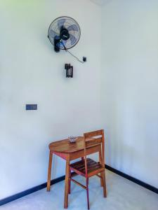 a small table with a fan on a white wall at YK House Midigama in Midigama East