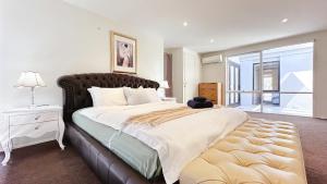 a bedroom with a large bed with a large window at Lakefront 6B4B House by GoodLive in Patterson Lakes
