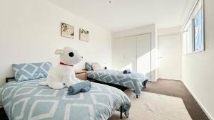 a bedroom with two beds and a stuffed animal sitting on a bed at Lakefront 6B4B House by GoodLive in Patterson Lakes +75 photos