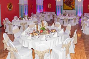 a banquet hall with white tables and chairs at Zur Alten Schmiede in Naumburg