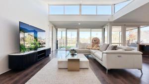 a living room with a teddy bear sitting on a couch at Lakefront 6B4B House by GoodLive in Patterson Lakes