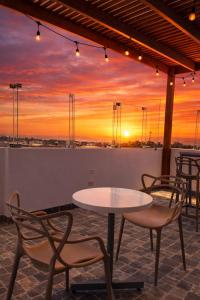 a table and chairs on a rooftop with a sunset at LAS GAVIOTAS DE PARACAS in Paracas