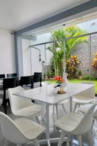 a white dining room with a white table and chairs at LAS GAVIOTAS DE PARACAS in Paracas