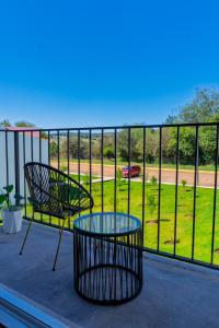 a balcony with two chairs and a glass table at Montepinar Acosta Suites in Mazamitla