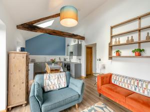 a living room with a couch and a kitchen at Kinder in Mellor