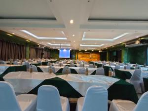 a banquet hall with white tables and chairs and a screen at Keeree at chiewlarn in Ban Tha Khun