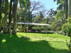 a gazebo in a park with palm trees at Thermal Paradise Villa in Caluco