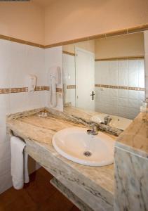 La salle de bains est pourvue d'un lavabo et d'un grand miroir. dans l'établissement Hotel Grifeu, à Llançà