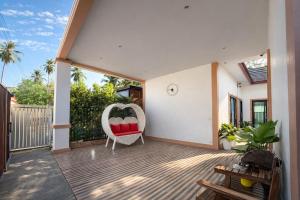 a porch with a white chair and a swing at Cocoloco Pool Villa Ao Nang in Ao Nang 