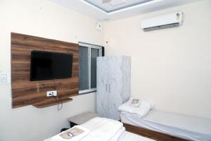 a room with two beds and a flat screen tv at Hotel Pujari in Khātu +64 photos