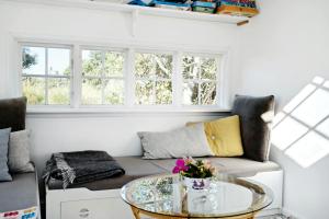 a living room with a couch and a glass table at Charming Tiny House In Sønderho in Fanø +23 photos