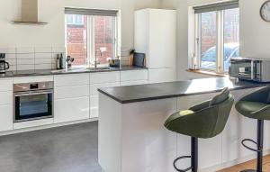 a kitchen with white cabinets and a black counter top at 2 Bedroom Awesome Home In Faaborg in Faaborg