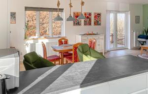 a kitchen and dining room with a table and chairs at 2 Bedroom Awesome Home In Faaborg in Faaborg +9 photos