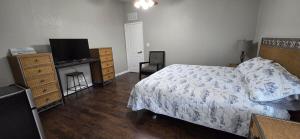 a bedroom with a bed and a dresser and a television at Spacious Private Room - Workspace - Las Cruces in Las Cruces