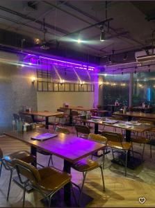 a restaurant with tables and chairs and purple lights at Căn hộ cao cấp Diamond Island Luxury Apartment in Ho Chi Minh City