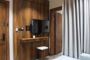 a room with a television on a wooden wall at فندق تربل ثري in Medina