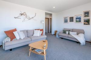 a living room with two couches and a table at Pohara's Beachside Bliss in Pohara