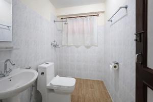 a white bathroom with a toilet and a sink at Funky Monkey Hostel Hotel & Apartment Thamel in Kathmandu +27 photos