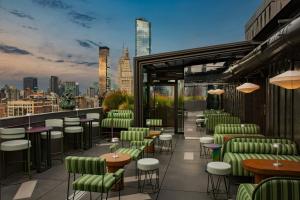 a rooftop bar with chairs and tables and a view of the city at W New York - Union Square in New York