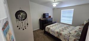 a bedroom with a bed and a dresser and a television at Spacious Private Room - Workspace - Las Cruces in Las Cruces