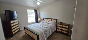 a bedroom with a bed and a flat screen tv at Spacious Private Room - Workspace - Las Cruces in Las Cruces +12 photos