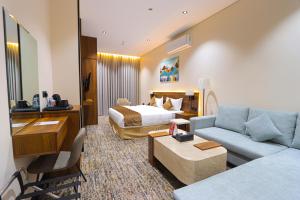 a hotel room with a bed and a couch at فندق تربل ثري in Medina