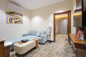 a living room with a couch and a tv at فندق تربل ثري in Medina