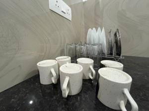 a group of cups sitting on a counter with vases at Montage Villa in Kozhikode +70 photos