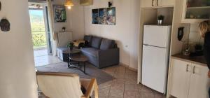 a kitchen and a living room with a couch and a refrigerator at Horizon studio apartment in Palaiokatoúna