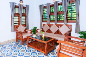 a living room with a couch and two chairs and a table at Niramaya Heritage Homestay in Kottayam