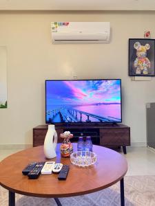 a living room with a table and a tv at شقة غرفة وصالة in Al Khobar