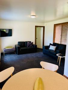 a living room with couches and a table at River Bend Caravan Park in Kanyapella