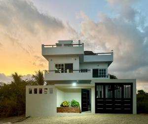 a white house with a sunset in the background at Brisa Marina in Playa Agua Blanca