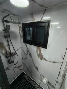 a bathroom with a black cabinet and marble walls at Studio MAT in Herly