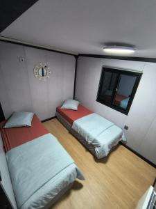 a small room with two beds and a window at Studio MAT in Herly
