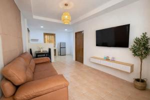 a living room with a couch and a flat screen tv at Labelle villa koh phangan in Ko Phangan