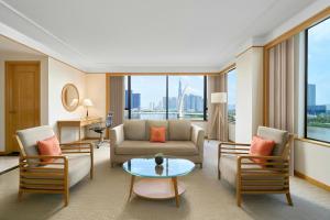 a living room with a couch and chairs and a table at Renaissance Riverside Hotel Saigon in Ho Chi Minh City
