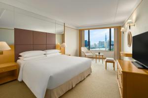 a hotel room with a large bed and a television at Renaissance Riverside Hotel Saigon in Ho Chi Minh City